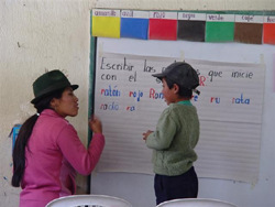 SFlorida Ante, a USAID-trained teacher, shows a student how to write at her school near La Vaquería, Ecuador.
