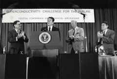 photo of Secretary of Energy John S. Herrington, Secretary of State George Schultz, Secretary of Defense Casper Weinberger applauding President Reagan at the Federal Conference on Commercial Applications of Superconductivity