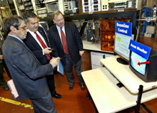 Secretary Abraham uses remote control "scissors" to cut an electronic ribbon