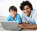 A father and son using a laptop computer.