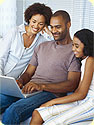 A mother, father and daughter using a laptop computer.