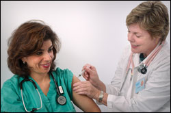 Photo: A doctor vaccinating a nurse.