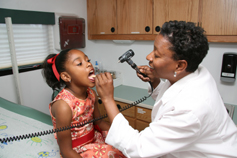 Dr. Persharon Dixon examining a child’s mouth.