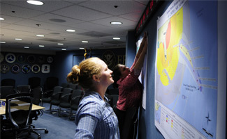Manuela Rayner (front) and Sarah Schoenborn, FEMA Mapping Division, prepare the National Response Coordination Center (NRCC), within FEMA Headquarters, with the current maps projecting the tracking of Hurricane Gustav and Tropical Storm Hannah. Barry Bahler/FEMA