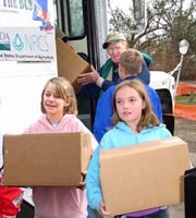 NRCS Illinois volunteer Charles Curry distributes school supplies to youngsters from Second Street Elementary School