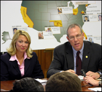 FBI exec James 'Chip' Burrus and Assistant Attorney General Alice Fisher, in front of a map showing recent examples of successfully prosecuted campaign finance cases.