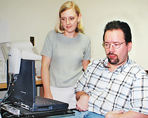 Photo: A job coach assists a client in learning new software at a computer workstation.