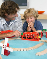 Adult playing trains with a boy