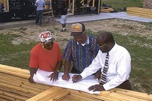 Daniel Kent, construction foreman, Robert Kent, housing director, and Community Development Manager Sylvester Pomerlee inspect plans for homes in Indianola, MS being built under USDA's self-help program.