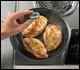 Checking internal temperature of pan-fried chicken breasts with a food thermometer.