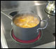 Soup or meat stock in a stockpot being brought to a boil.