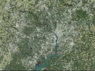 Starting with a view of the Washington, D.C., metropolitan area, the D.C. border and the Beltway fade in.  The view then shifts to Mount Airy, Maryland, indicating urban growth with red dots.  Data sets for 1973, 1980, 1985, 1990, and 1996 are presented chronologically.