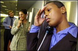 Picture of woman talking on a pay phone and holding her head