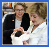 Laura Bush & ED Secretary Margaret Spellings holding a baby