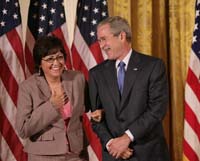 President George W. Bush presented the President’s Volunteer Service Award to Maria Hines of Albuquerque, New Mexico in a ceremony in the East Room of the White House on October 7, 2005. The ceremony, part of a White House celebration of Hispanic Heritage Month, was also attended by Attorney General Alberto Gonzales and Secretary of Commerce Carlos Gutierrez.