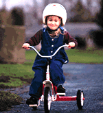 image of girl riding tricycle and wearing a helmet