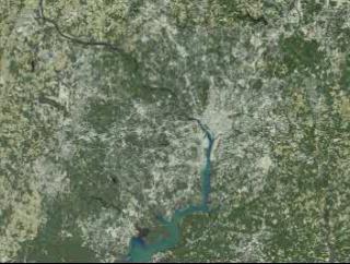 Starting with a view of the Washington, D.C., metropolitan area, the D.C. border and the Beltway fade in.  The view then shifts to Reston and Sterling, Virginia, indicating urban growth with red dots.  Data sets for 1973, 1980, 1985, 1990, and 1996 are presented chronologically.