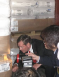 The Honorable Michael O. Leavitt, U.S. Secretary of Health and Human Services, joins officials from the Shanghai Entry-Exit Inspection and Quarantine Bureau to look at goods in a container at the Waigaoqiao Section of the Port of Shanghai.