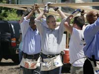 President George W. Bush helps volunteers from Operation Rebuilding Hands with the construction of a home in New Orleans, Louisiana, Thursday, April 27, 2006. Also pictured are Congressman Bill Jefferson, left, and New Orleans Mayor Ray Nagin.