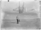  Side view of Dan Tate, left, and Wilbur, right, flying the 1902 glider as a kite. 
