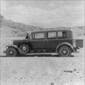 Side view of two automobiles, one a convertible, with Black Mesa, Arizona in the background, ca. 1924.