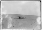  The remodeled 1905 Wright machine, altered to allow the operator to assume a sitting position and to provide a seat for a passenger, on the launching track at Kill Devil Hills. This is apparently the only photograph of this machine taken by the Wright brothers in 1908.

