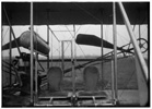  Close-up view of airplane, including the pilot and passenger seats. 

