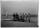  Group portrait in front of glider at Kill Devil Hill. Sitting: Horace Wright, Orville Wright, and Alexander Ogilvie; standing: Lorin Wright, and group of journalists, including Van Ness Harwood of the New York World, Berges of the American News Service, Arnold Kruckman of the New York American, Mitchell of the New York Herald, and John Mitchell of the Associated Press; Kitty Hawk, North Carolina

