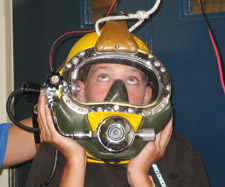 camper trying on a diving helmet