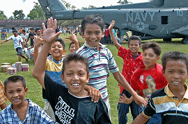 Indonesian children gather around a U.S. Navy helicopter as air crewmen offload supplies in Lamno, Indonesia.  U.S. Navy photo by Photographer's Mate 1st Class Alan D. Monyelle.