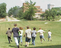 photo: Group of students running across a grassy field