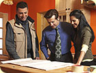 A man, woman and contractor looking at 
		   remodeling plans.