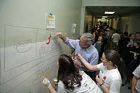President George W. Bush lends a hand and his best brush strokes at Cardozo Senior High School in Washington, D.C., as volunteers spend Martin Luther King, Jr. Day painting murals of historical figures and local landmarks like the front of "Ben’s Chili Bowl" Monday, Jan. 15, 2007.
