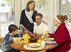 A mom, dad, daughter and son having breakfast.