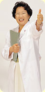 A woman wearing a lab coat giving a thumbs up sign.