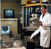 NIST post doctoral research fellow Mark Iadicola examines a sample of sheet metal that has been tested with NIST's new formability testing station.