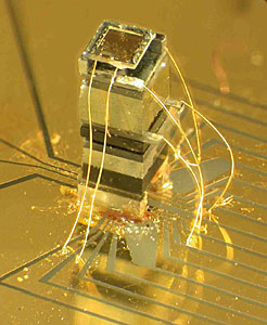 Photo of the NIST chip-scale magnetometer. The sensor is about as tall as a grain of rice. The widest block near the top of the device is an enclosed, transparent cell that holds a vapor of rubidium atoms.
