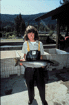 Image of a woman holding salmon.  Migrating Salmon Research