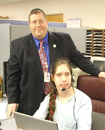 DORS counselor Klainberg standing behind a female student using adapted AT computer equipment 