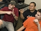 A computer science professor communicates in sign language to three students in a computer lab.