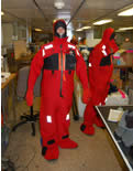 Safety Meeting onboard R/V Thompson: trying on a survival "gumby" suit.