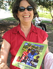 Woman holding a hand fan with a Jacob Lawrence image