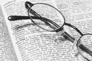 eyeglasses sitting on an open dictionary.