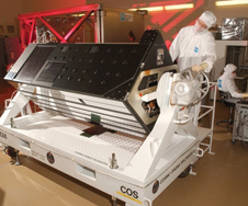 Man in clean room looking at COS instrument