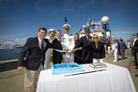 The ship's commissioning party ceremoniously cuts the first piece of commissioning cake.