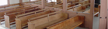 Wooden benches inside a Quaker meetinghouse.