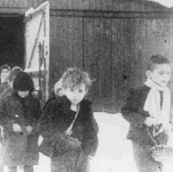 Soon after liberation, surviving children of the Auschwitz camp walk out of the children's barracks. Poland, after January 27, 1945.