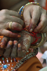 A married Hindu woman ties holy thread on anothers wrist during Hindu festival of Vat Savitri in Ahmadabad, India, Wednesday, June 18, 2008. [AP Image]
