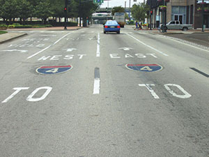 Route markers on the pavement approaches to this intersection in Orlando, FL, help guide motorists to interstate access.