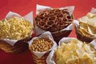 Image of snacks: popcorn, pretzels, tortilla chips, peanuts, and potatoe chips
